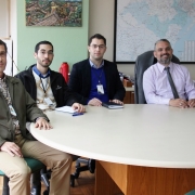 A foto mostra o diretor de Administração e Finanças do Daer, Saul Sastre, posando para a foto em sua mesa acompanhado dos representantes do Tribunal de Contas que vieram conhecer o programa de reestruturação do Daer.